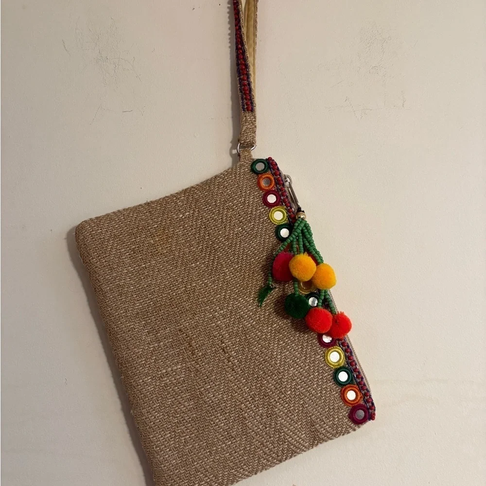 bohemian-style woven clutch jute with pom pom accents